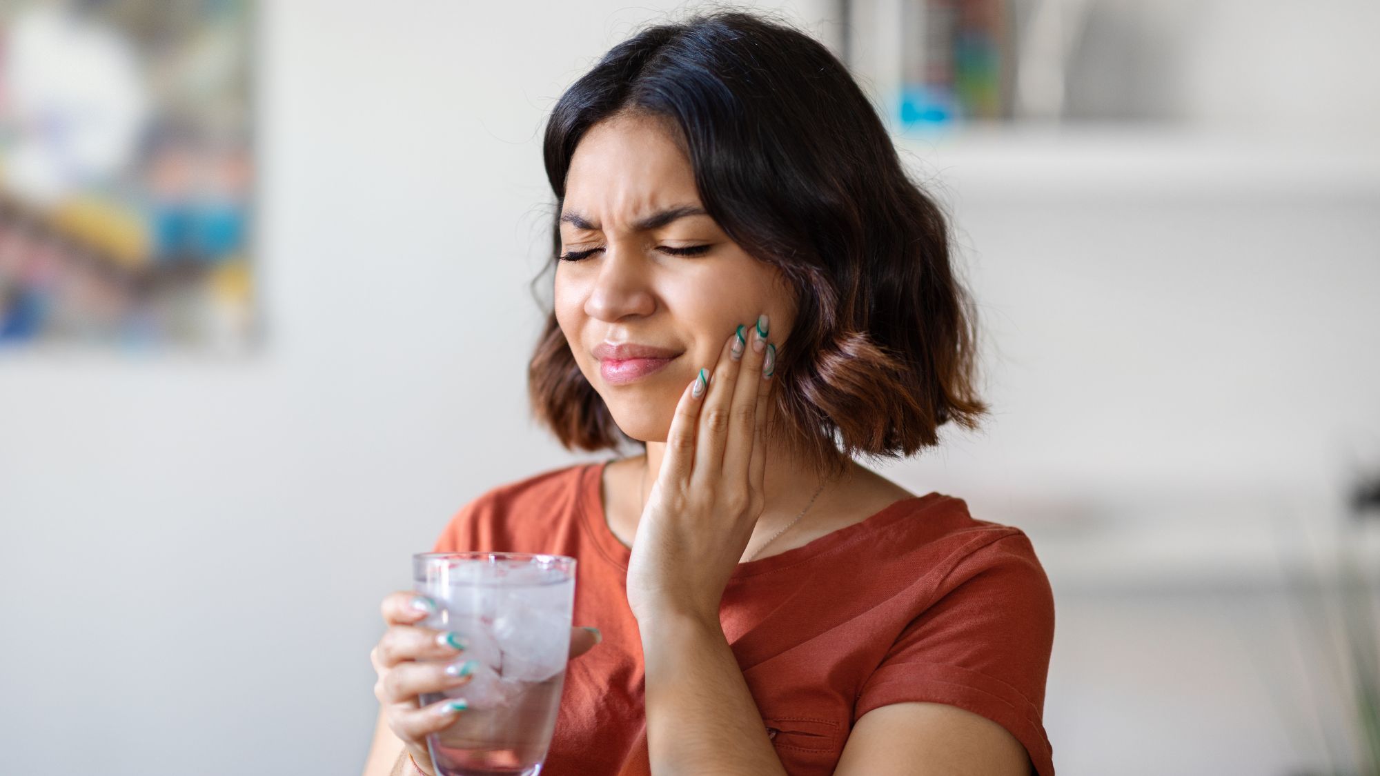A woman holding her mouth due to teeth sensitivity after teeth filling